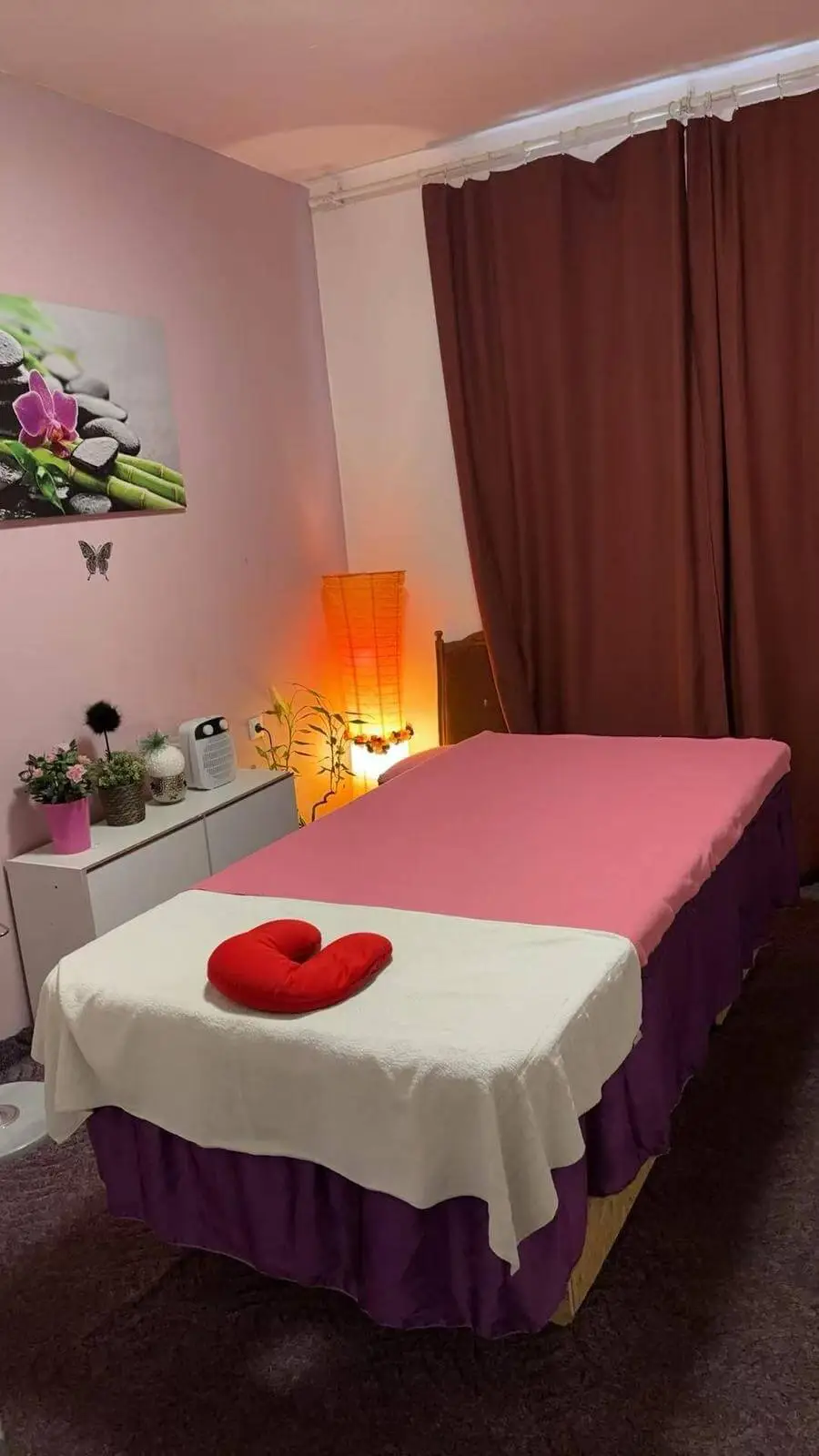 Kleines Badezimmer mit Waschbecken, weißen Fliesen und Orchideen-Wanddekoration.