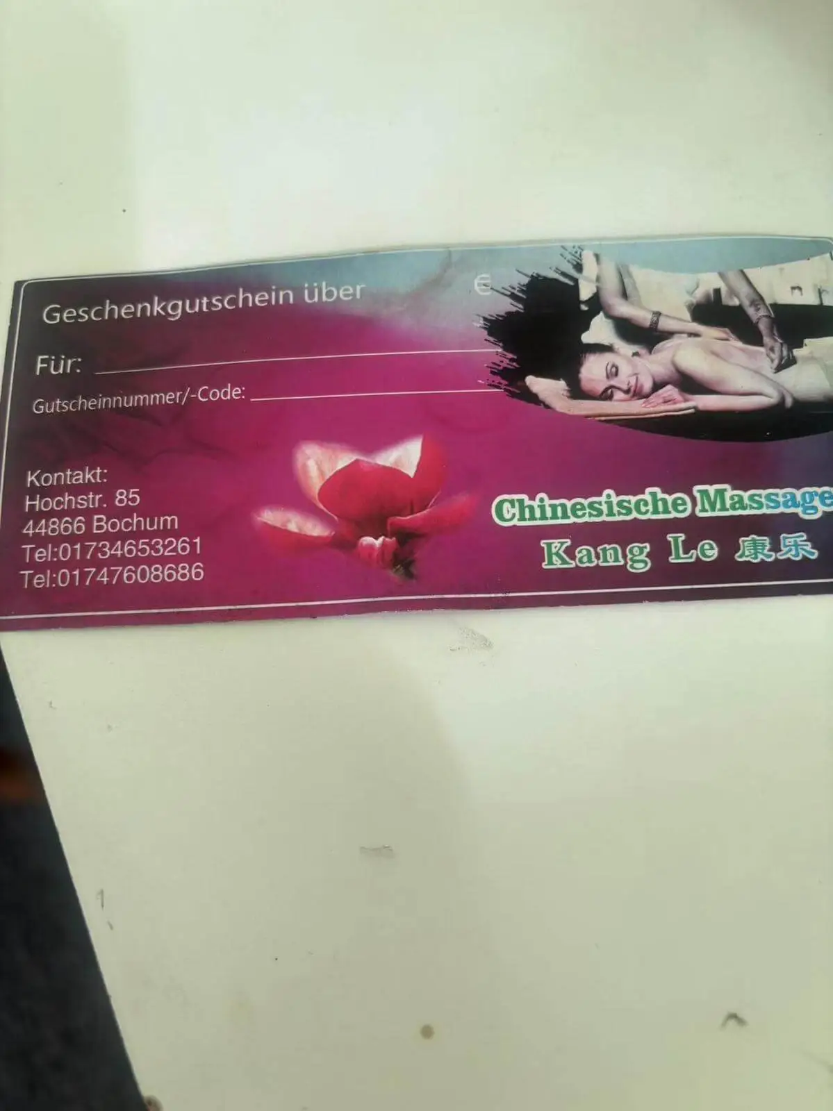 Außenansicht eines Massagesalons mit roter Backsteinwand und Yin-Yang-Logo auf dem Fenster.